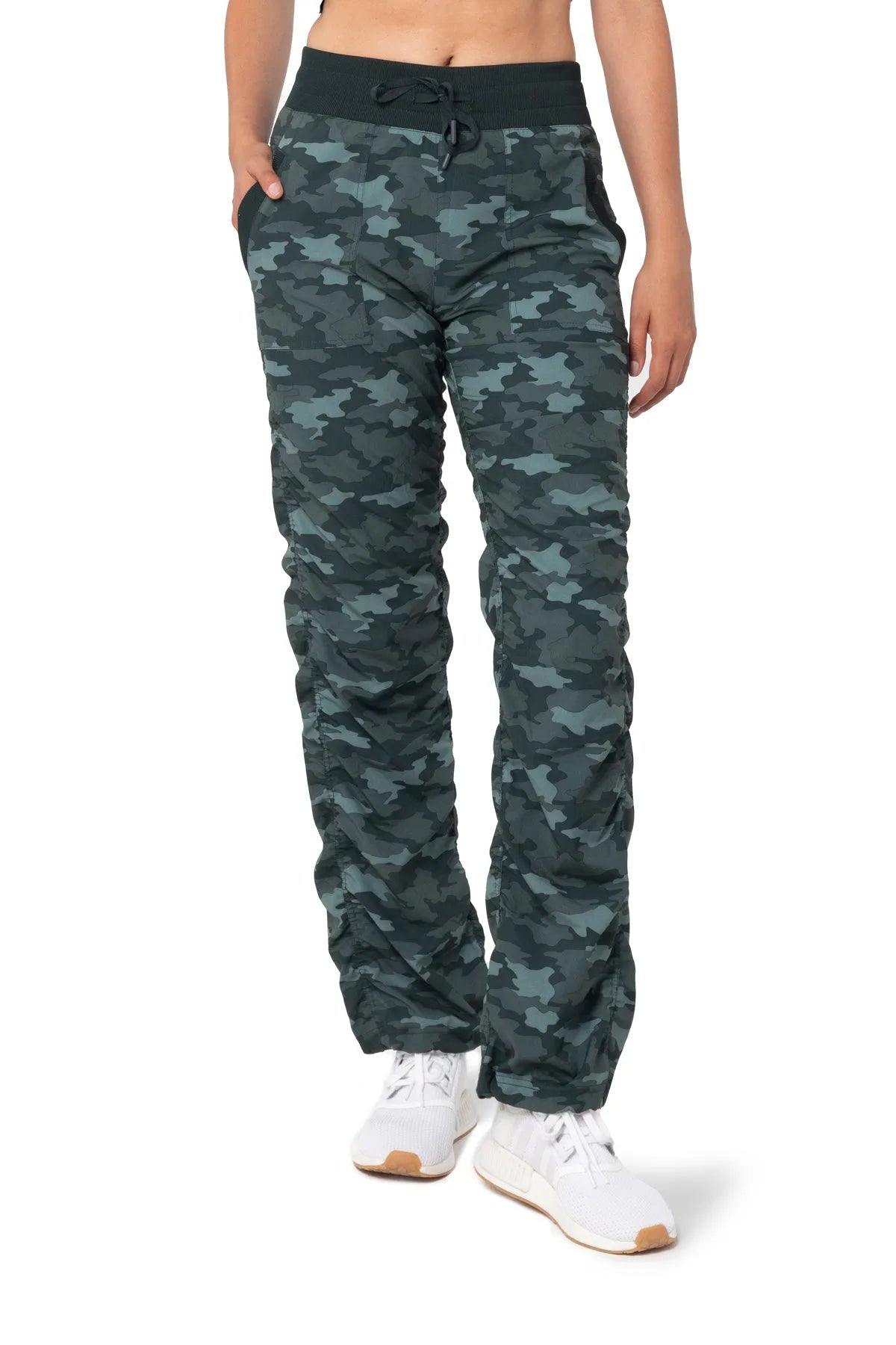 Women’s Black and green camouflage print Adventurous Pant, front lower-body studio view showing the drawstring waist, patch pockets and gathered cuffs.