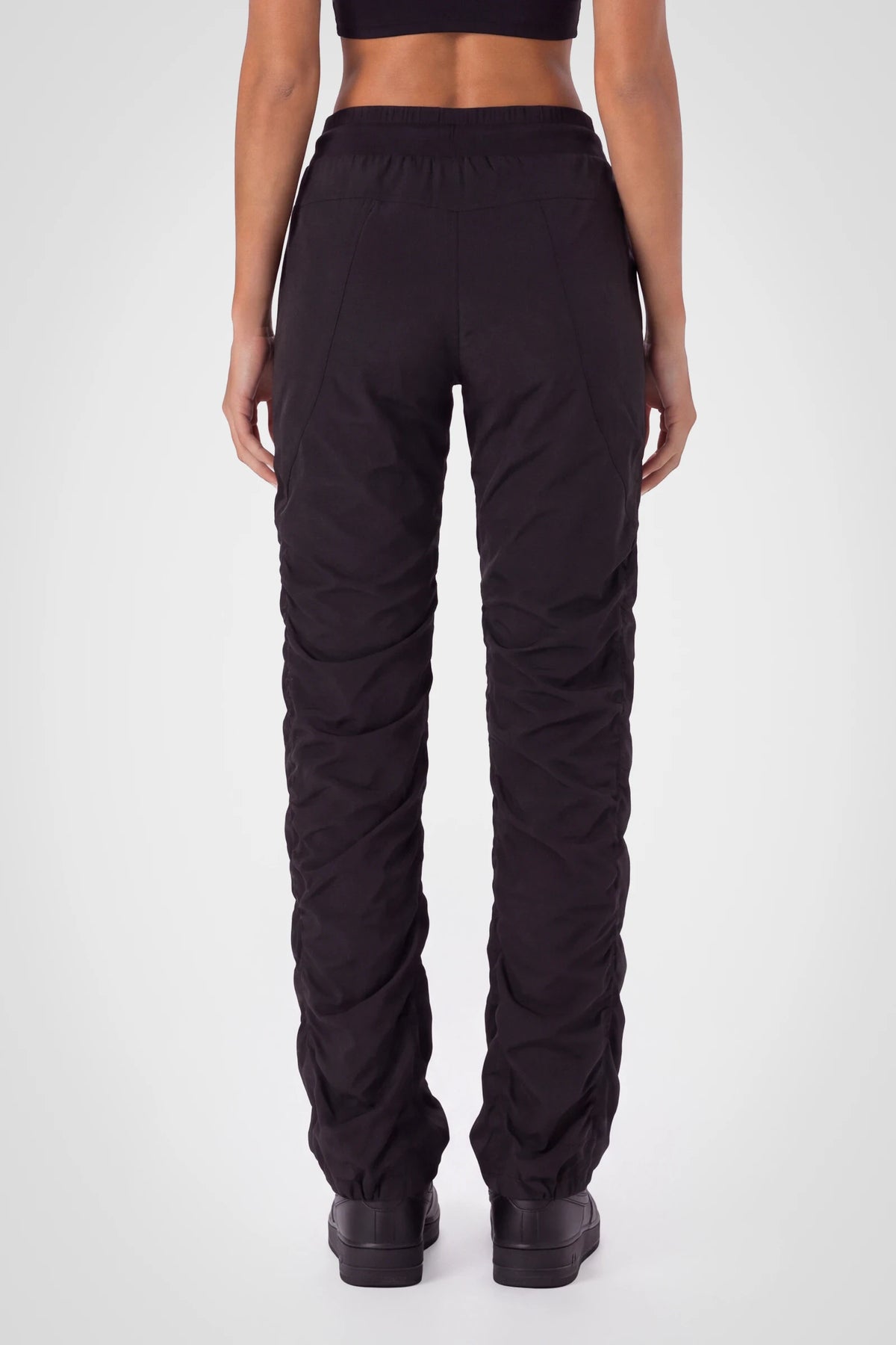 Women’s Black Adventurous Pant, rear three-quarter studio view showing the relaxed fit through the seat and gathered cuffs.