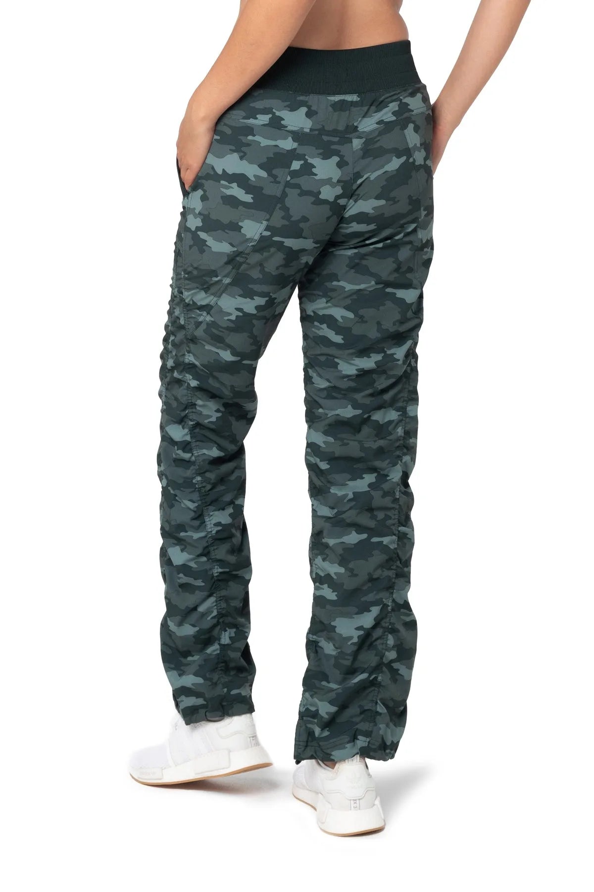 Women’s Black and green camouflage print Adventurous Pant, angled studio pose showing the utility pocket, tapered leg and elastic cuff.