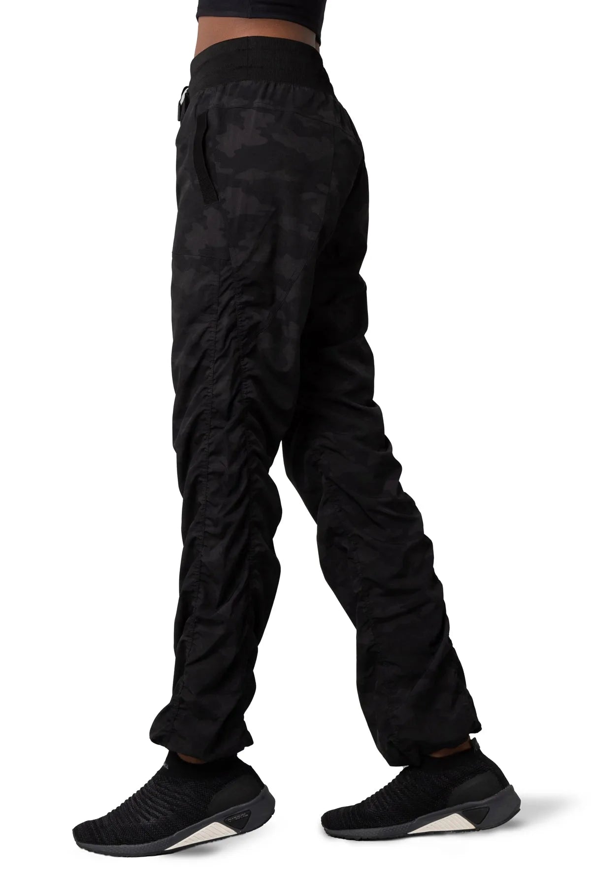 Women’s Dark camouflage print Adventurous Pant, three-quarter studio view showing the relaxed tapered leg and utility pocket.