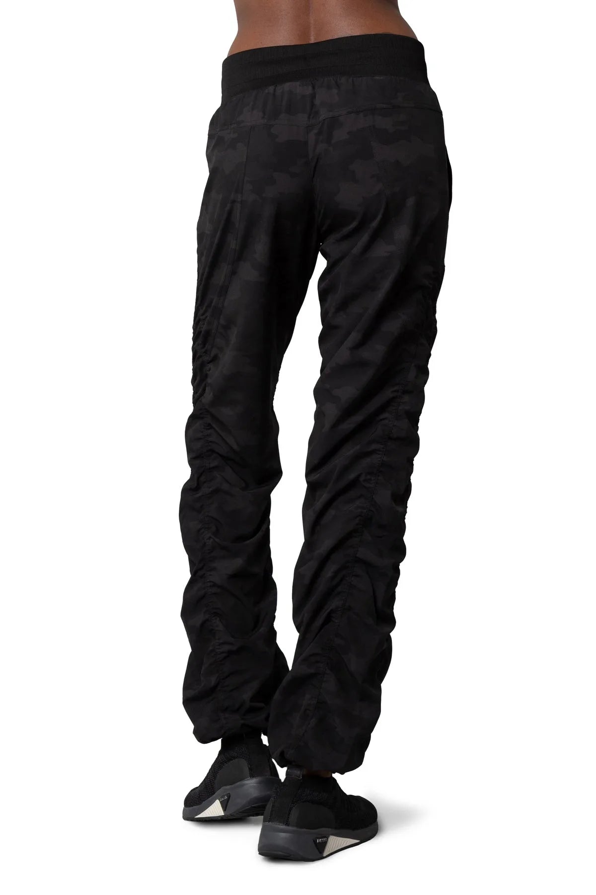 Women’s Dark camouflage print Adventurous Pant, rear three-quarter studio view showing the relaxed fit through the seat and ankle.