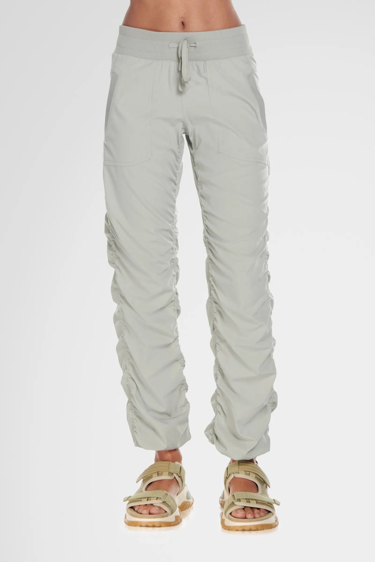 Women’s Cement Adventurous Pant, front lower-body studio view showing the elastic drawstring waist, patch pockets and gathered cuffs.