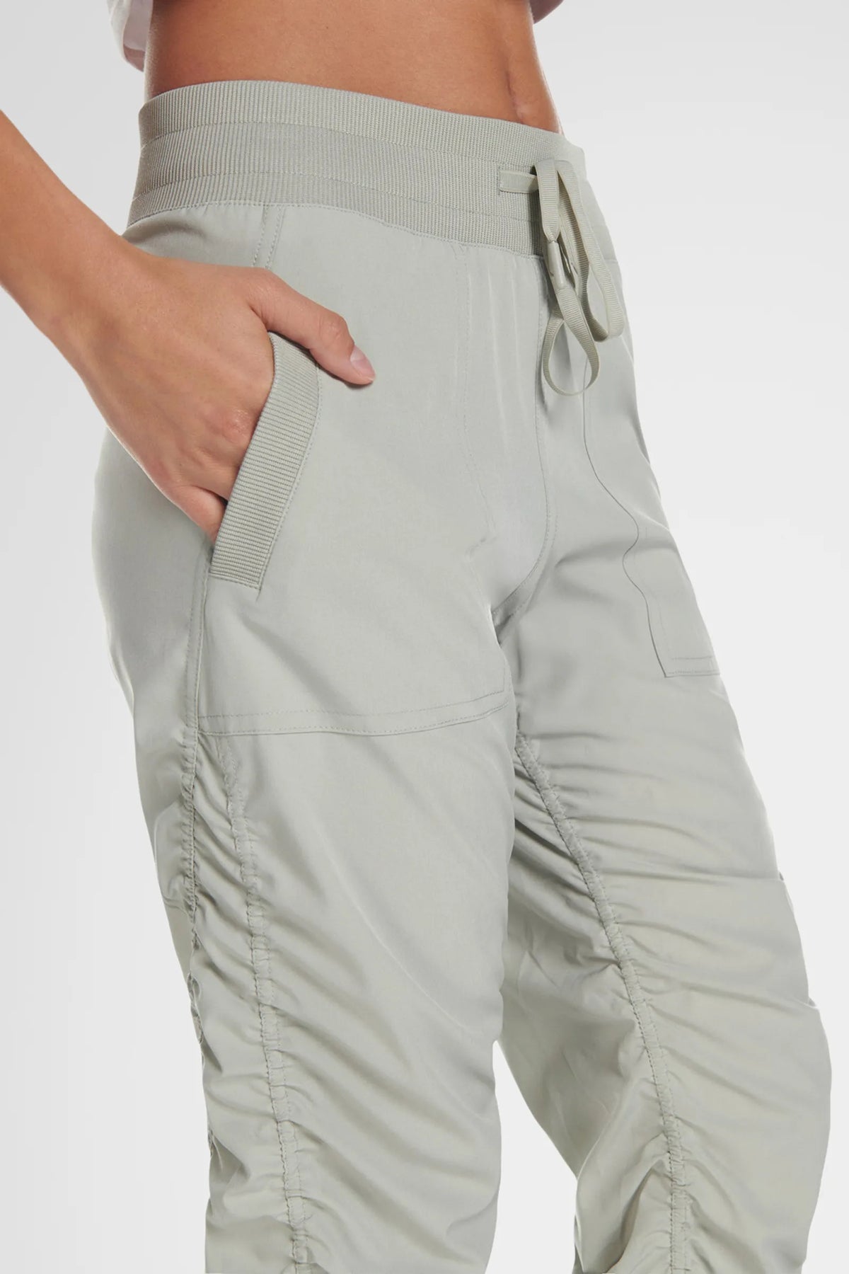 Women’s Cement Adventurous Pant, side close-up showing the oversized utility pocket and relaxed tapered leg.
