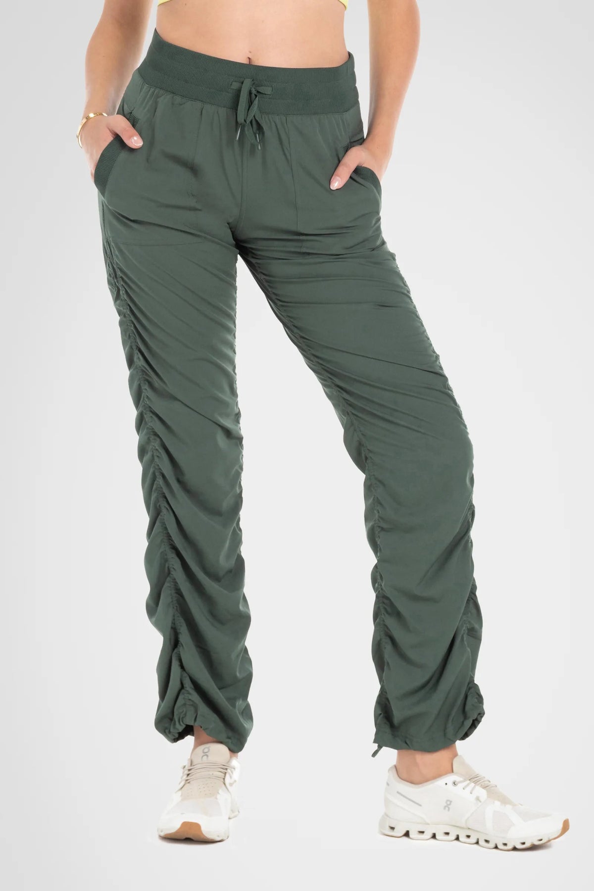 Women’s Cilantro Adventurous Pant, front lower-body studio view showing the elastic drawstring waist, patch pockets and gathered cuffs.