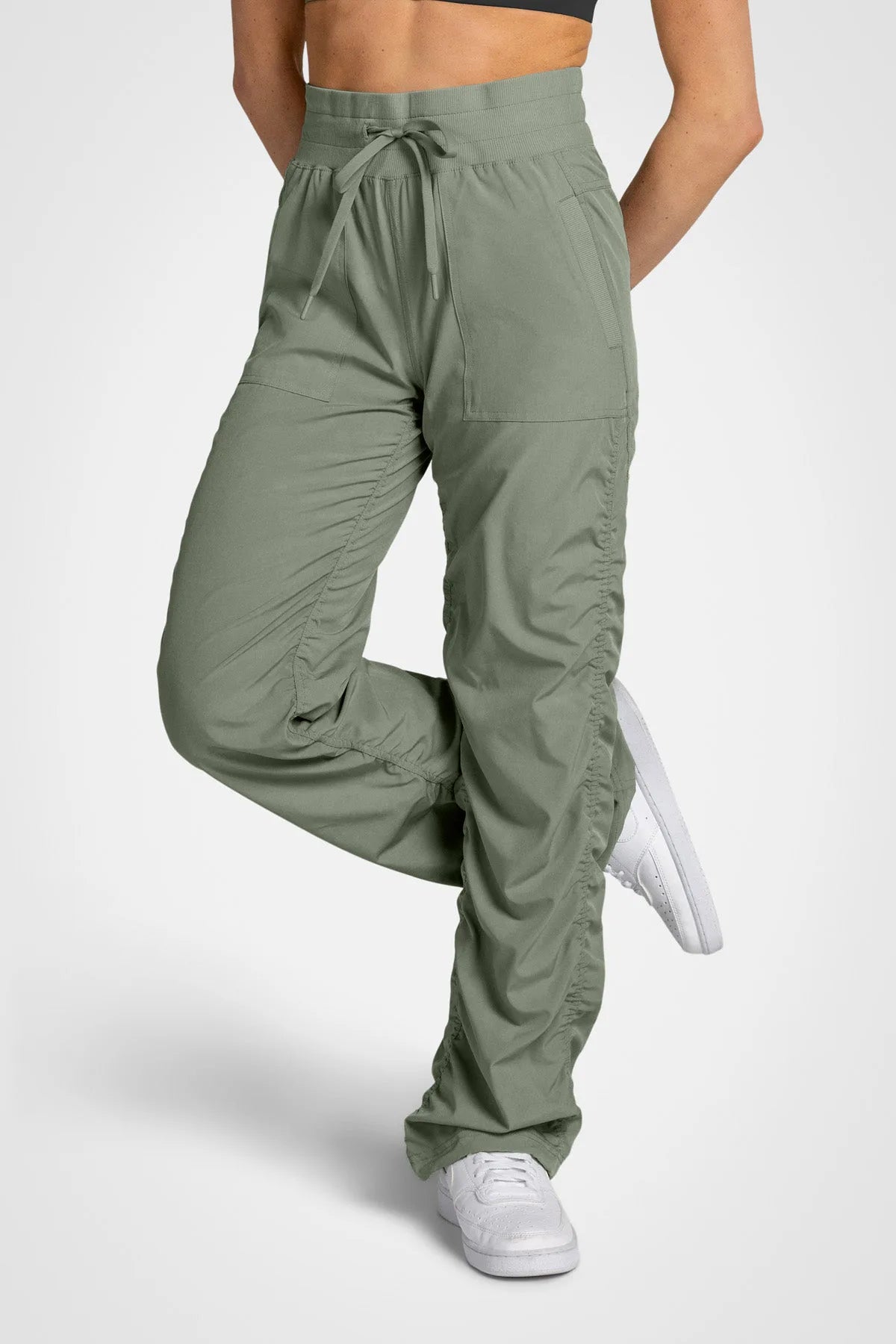 Women’s Laurel Adventurous Pant, front lower-body studio view showing the elastic drawstring waist, patch pockets and gathered cuffs.