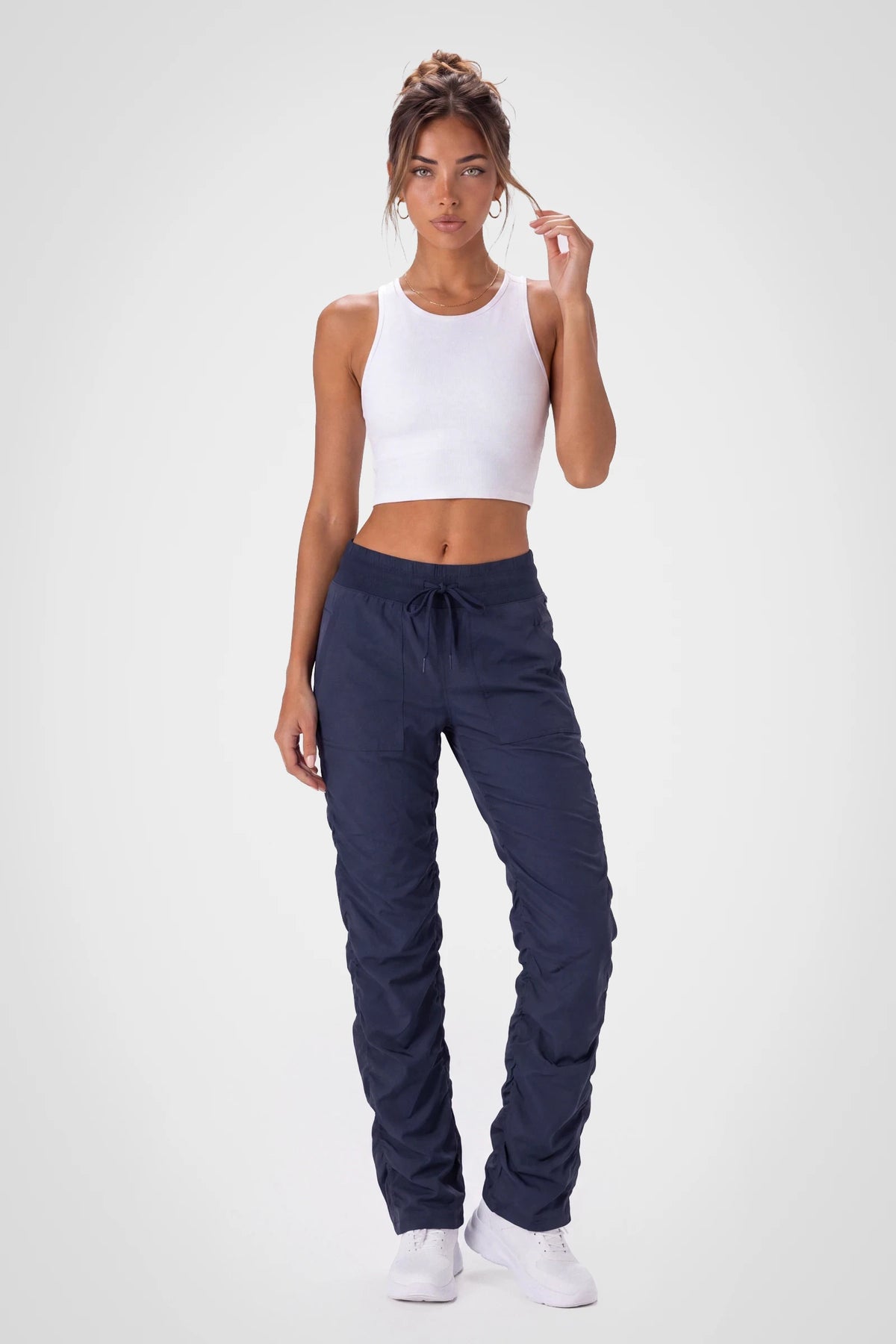 Women’s Navy Adventurous Pant, side studio view showing the relaxed tapered leg, patch pocket and gathered cuff.